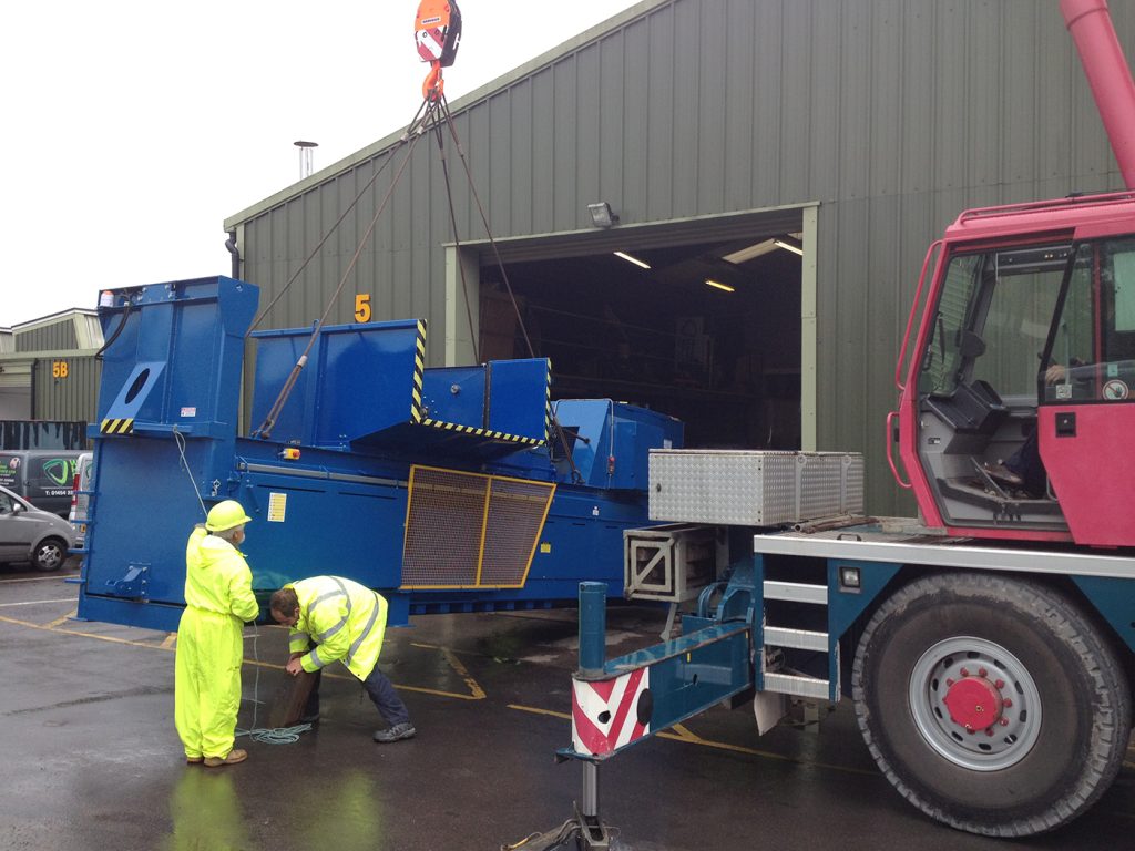 Baler being craned into an industrial unit to be installed.
