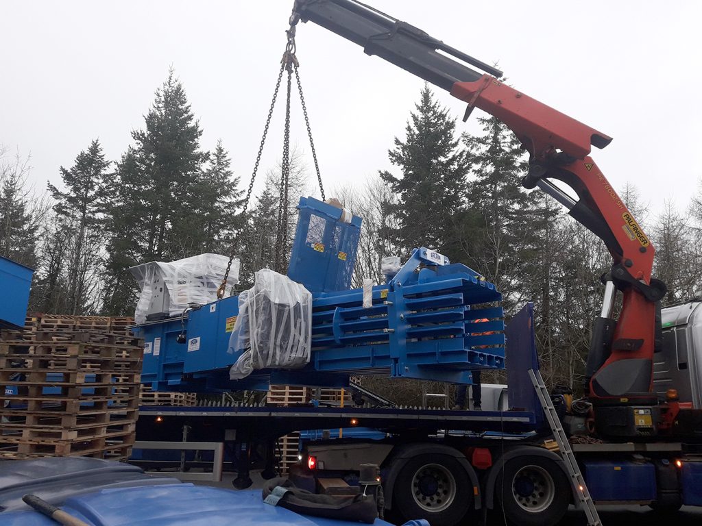 A baler being craned off a flat bed lorry for installation.