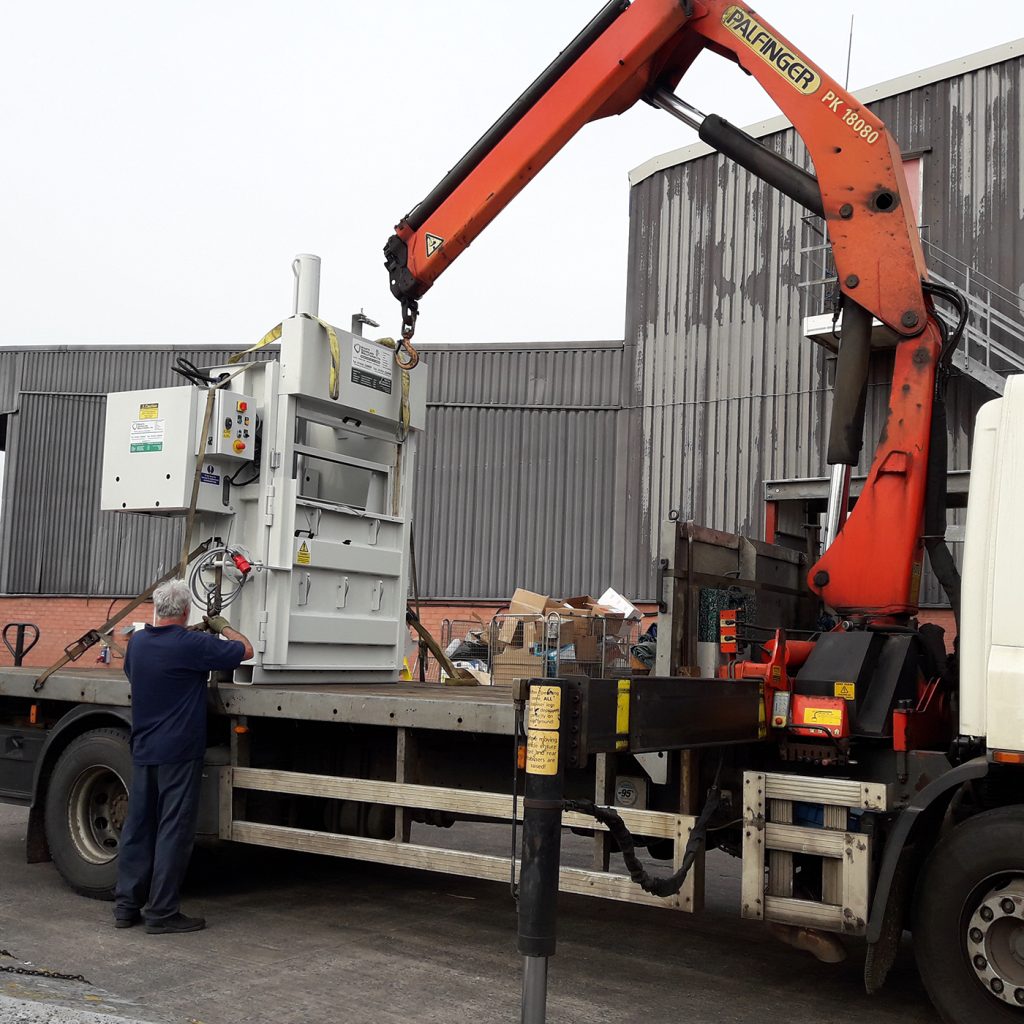 Vertical Mill Sized Baler being prepared to be lifted off the flat-bed truck for installation.